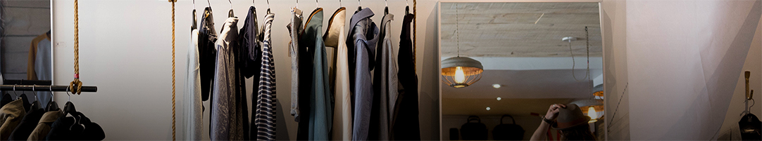 several items of men's clothes hanging on a rack in a store