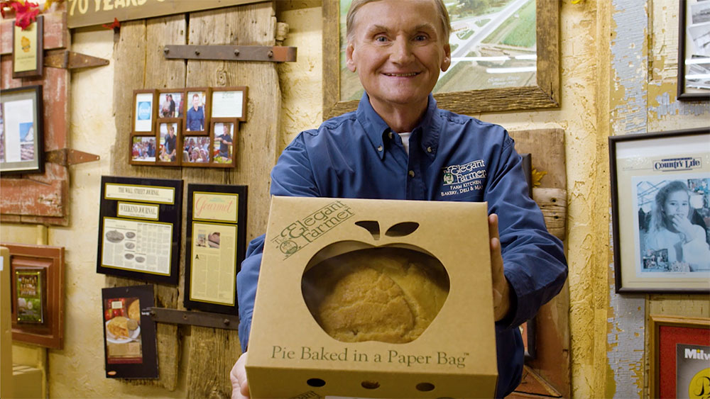 Elegant Farmer owner holding one the company's renowned apple pies