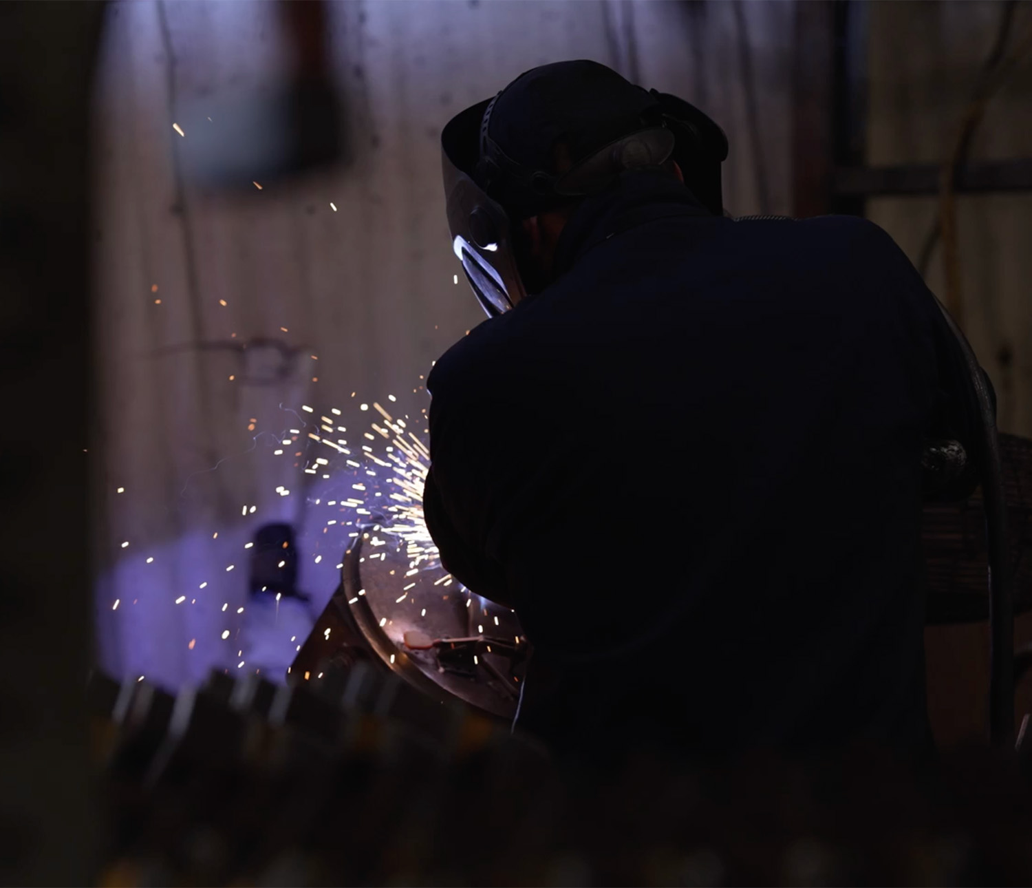 Sparks flying as a manufacturing employee works in a factory