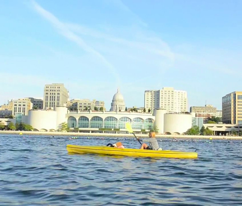 Woman rowing on Lake Monona in Madison, Wisconsin, with the state capitol in the background — video marketing